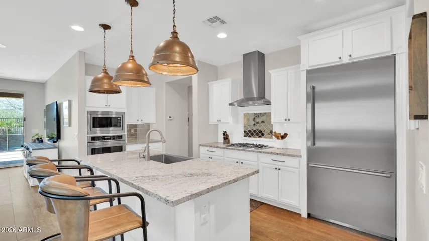 Well-appointed kitchen with Monogram appliances, built-in Thermador refrigerator, oversized island with seating, and butler’s pantry.