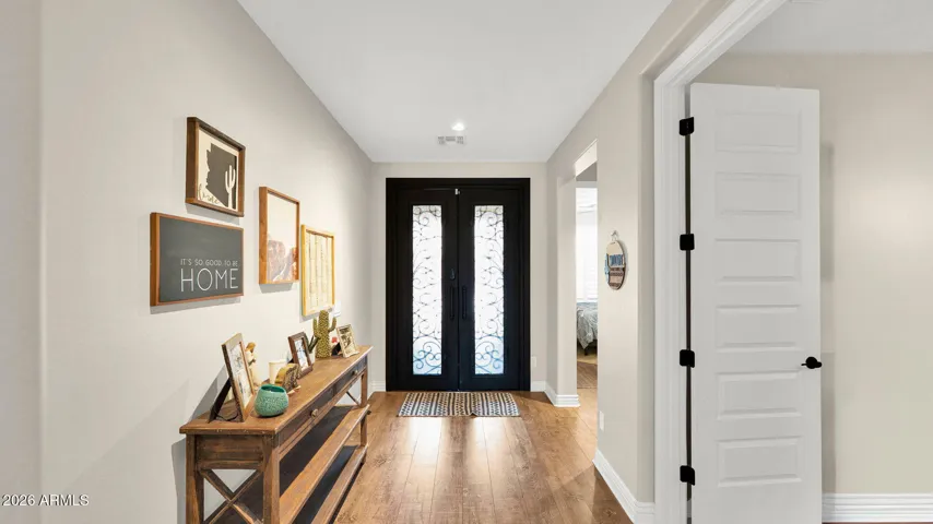 Spacious interior entry with custom ironwork double doors, creating a welcoming first impression and a defined transition into the main living areas.