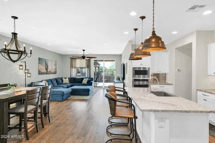 Open-concept kitchen, dining, and great room designed for connection, featuring an oversized island and custom lighting.