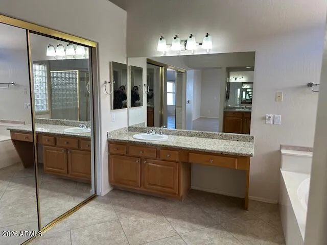 Primary bath has been highly graded with custom lighting, a large soaker tub with glass block at the window, granite countertops and large designer tile. The split vanity areas and mirrored closet doors are just a few more enhancements to this fabulous bath.