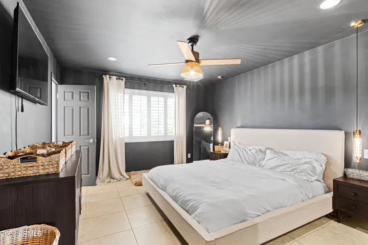 Large master suite with custom pendant lighting, low voltage lights, and artistic ceiling fans.
