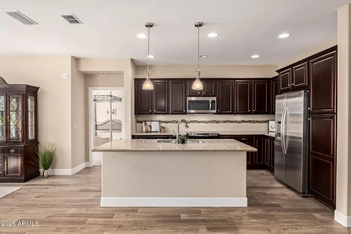 Upgraded kitchen with granite counters, full height backsplash, pendant lights and more