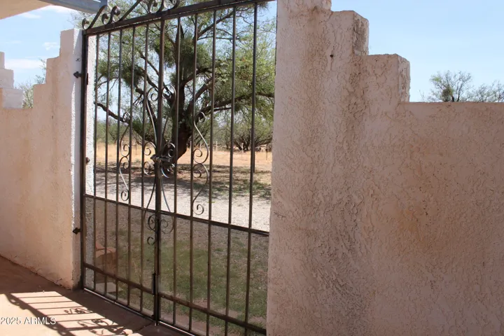 Custom wrought iron gate secures courtyard