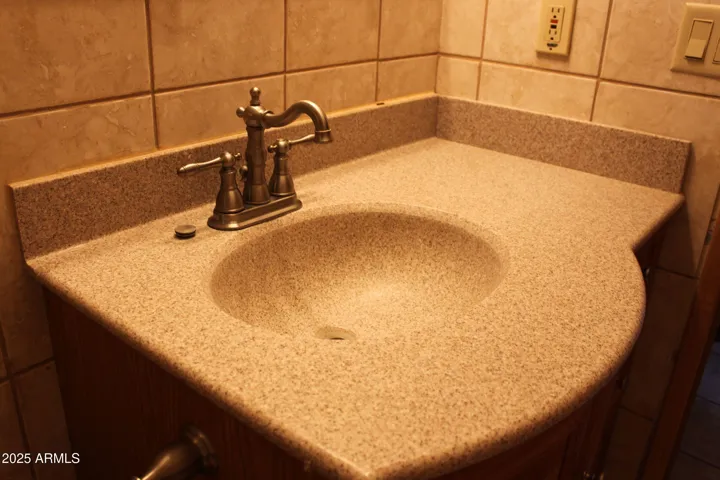 Granite counter and modern faucet in guest bath