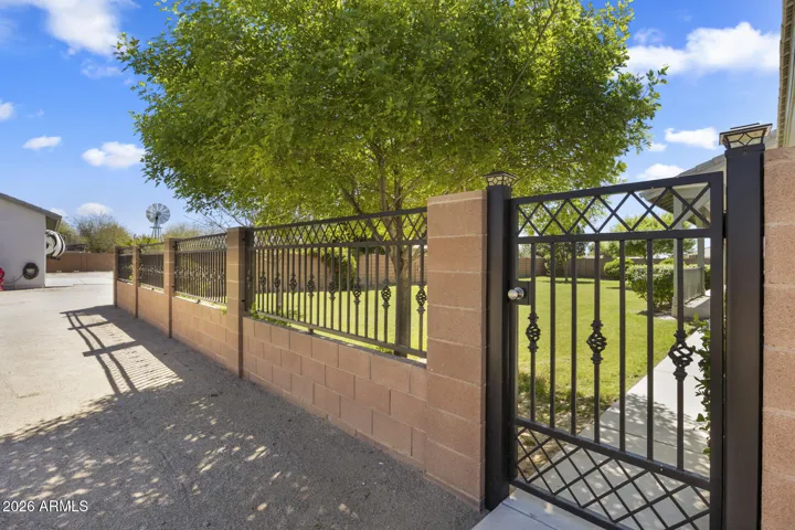 private back yard that extends off of the back patio fenced off with partial view fencing