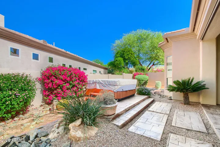 enjoy the landscaped yard with hot tub and modern stepping stones
