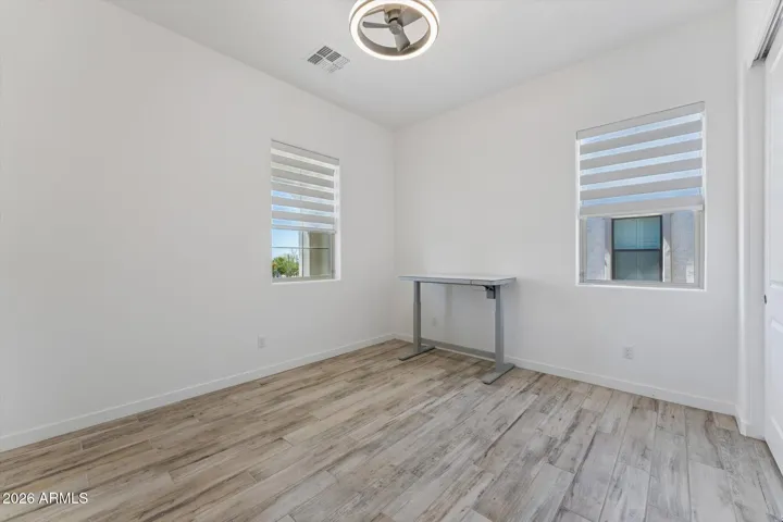 Large guest bedroom with Tile Floors, Motorized Blinds, and Modern fan/light