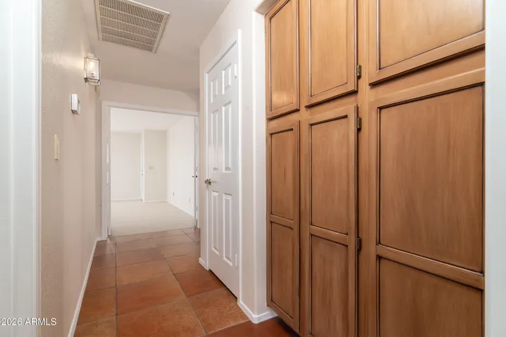 Hallway with storage cabinets, coat closet