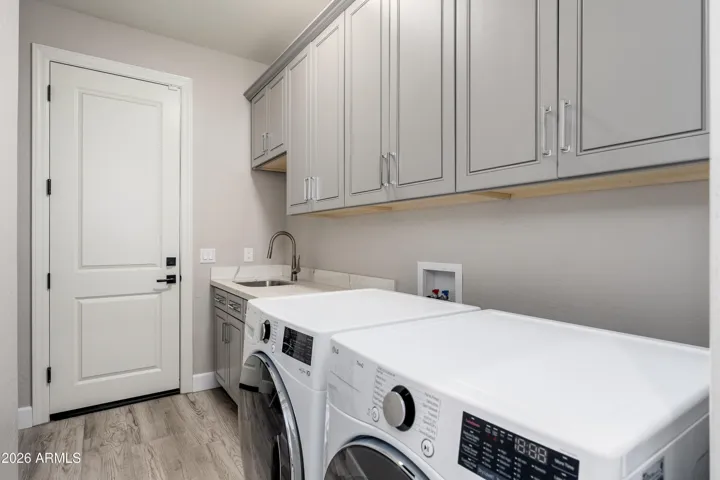 Laundry room with cabinets, sink and room for refrigerator