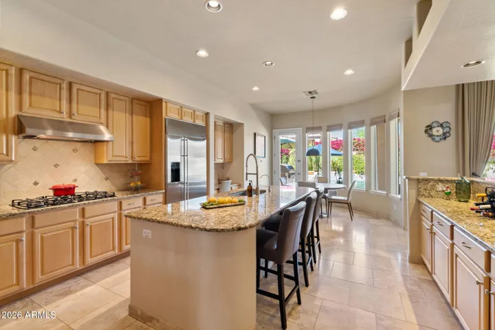 Kitchen with large island and bay window looking into the fully landscaped yard