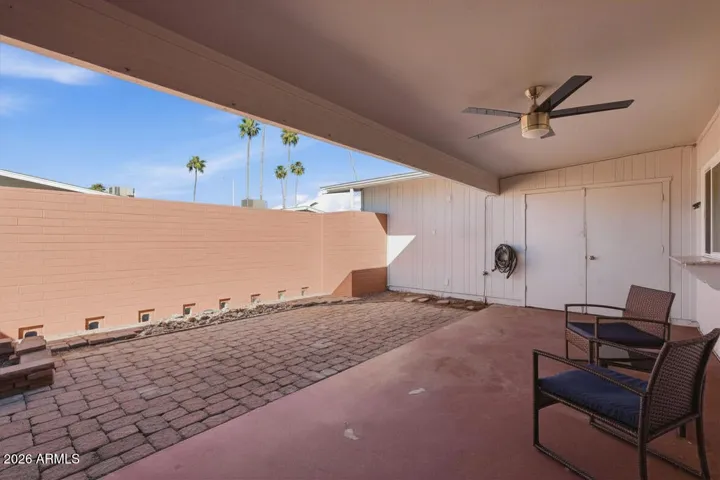 Private backyard covered patio with storage space in locking storage and room for golf cart parking.
