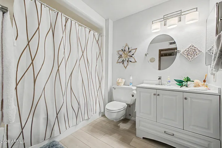 Hall Bath is equipped with the gigantic vintage tub/shower combo, floating toilet & the newer shaker cabinet, counters, sink laminate flooring & mirror