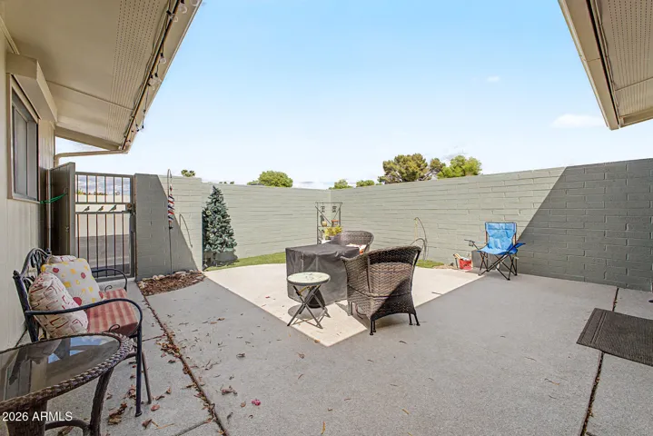 Newly painted block wall surrounds a nice size patio area. Security screen door exits to the alley.
From patio to the garage entry door. The garage is 1.5 and has built in cabinets & opener. The seller is leaving the garage frig and the 2023 washer and dryer.