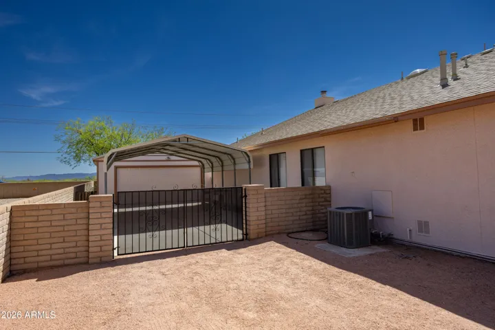 Gated entry to the 2nd garage and carport on left side of home