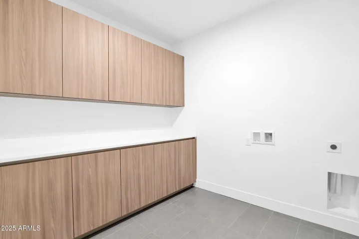 Spacious laundry room with upper and lower cabinetry.