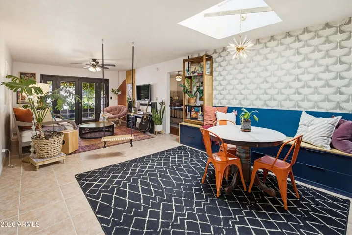 Open concept floor plan living and dining rooms. Built in bench seating and mcm designer wallpaper