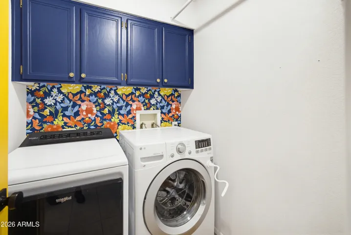 Laundry room with designer wallpaper and ample storage