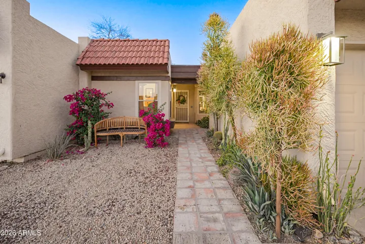 Great curb appeal. Lighting, colorful plants, pavers with character.