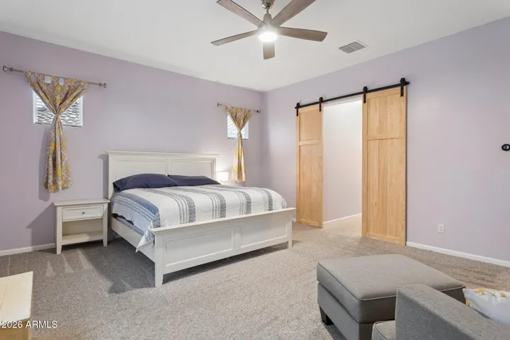 Barn doors connect the primary bedroom and bath with style