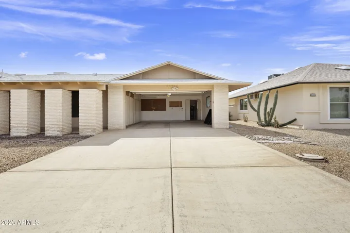 Front of House with large driveway and cabinets in garage