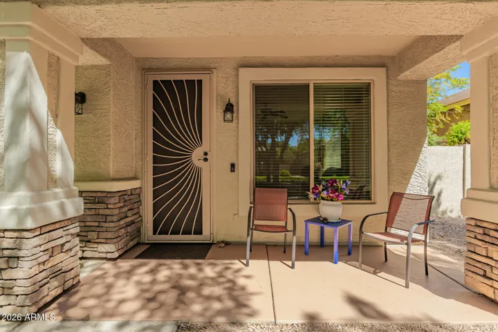Peaceful covered front patio entry w/ custom security screen door. South exposure all shaded!