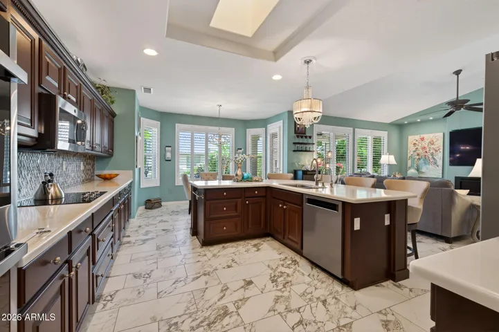 Center island. Dark cherry. Quartz counters. Glass back-splash. Chandelier. Skylight.