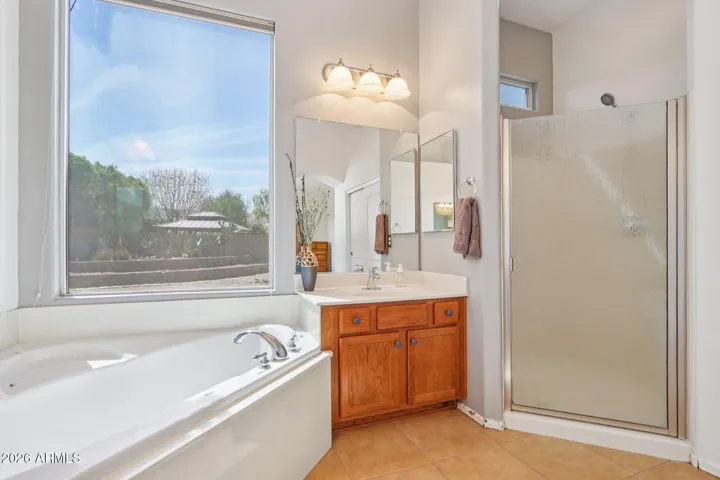 primary bathroom features separate walk in shower and tub