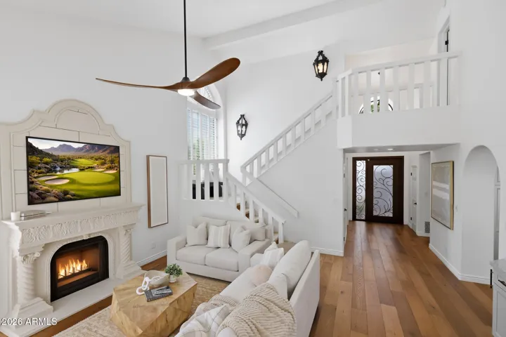 Light-filled living room with vaulted ceilings, fireplace, and wood floors