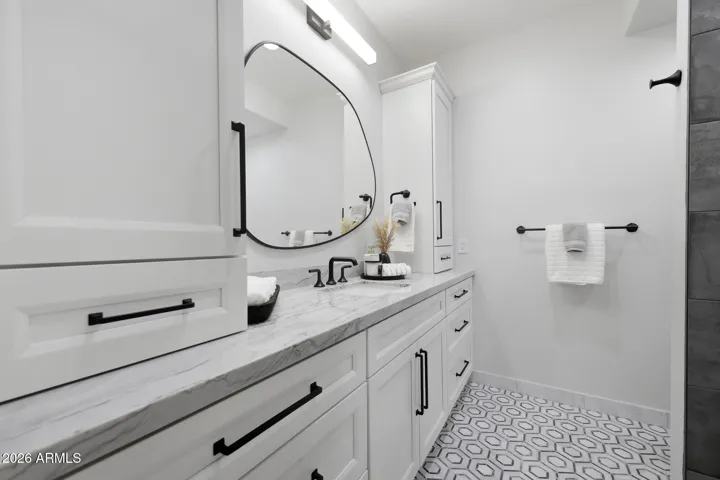 With marble flooring, quartzite countertops, and frameless glass shower