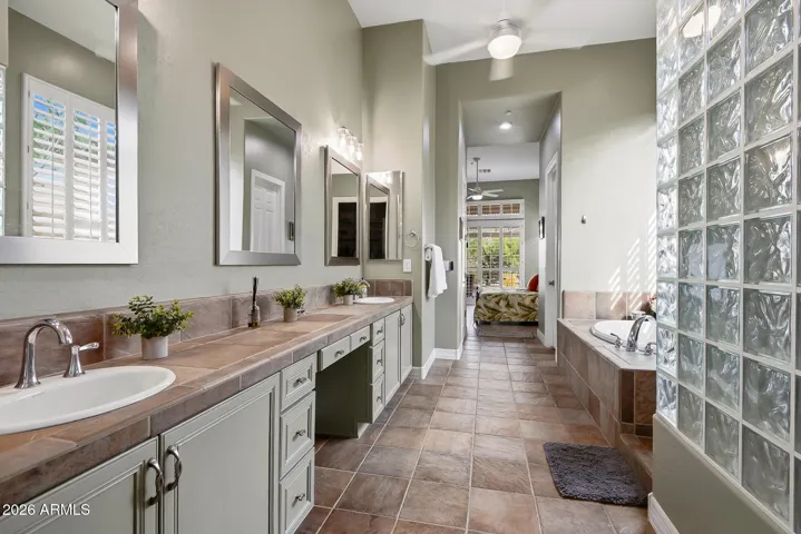 Luxurious bathroom with dual sinks, vanity and large walk in closet.