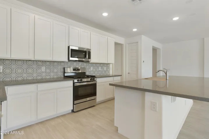 BEAUTIFUL PAINTED LINEN 42" CABINETS, UPGRADED GAS RANGE, QUARTZ COUNTERS AND A DESIGNER BACKSPLASH!