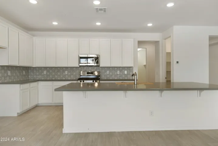 BEAUTIFUL PAINTED LINEN 42" CABINETS, UPGRADED GAS RANGE, QUARTZ COUNTERS AND A DESIGNER BACKSPLASH!