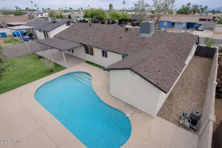 Private backyard with sparkling pool, covered patio, and low-maintenance landscaping