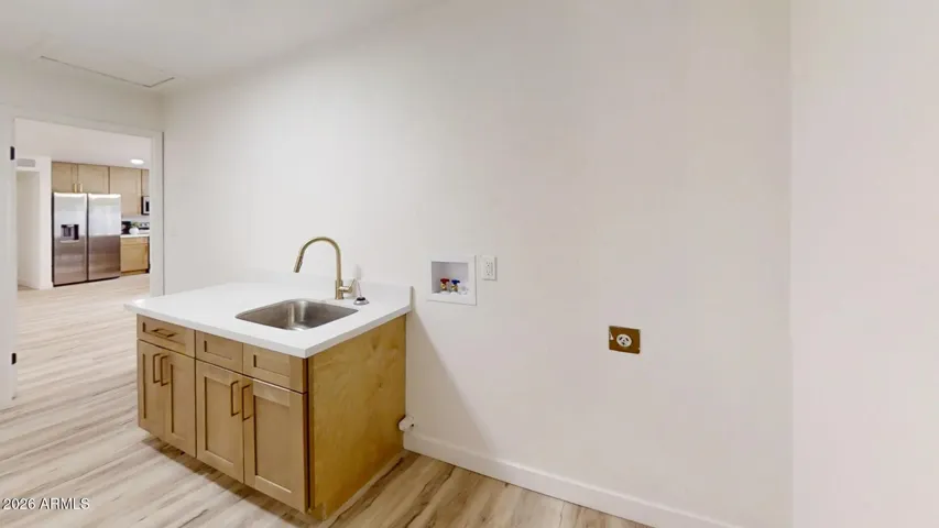 Dedicated laundry area with utility sink and additional storage space