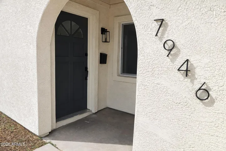 Inviting front entry with arched walkway, modern door, and updated exterior details