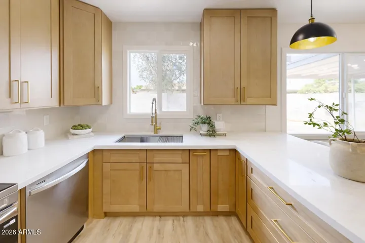 Designer kitchen with quartz countertops, custom cabinetry, and matte gold fixtures