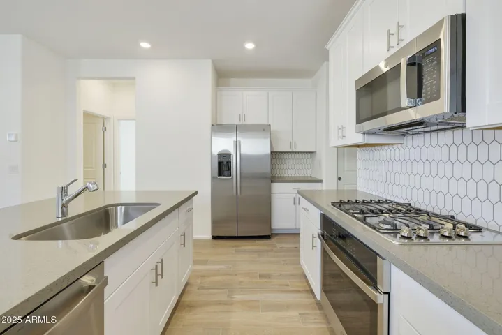 BEAUTIFUL PAINTED CABINETS, UPGRADED QUARTZ COUNTERS, DESIGNER BACKSPLASH, GAS COOKTOP, BUILT-IN OVEN AND REFRIGERATOR INCLUDED!!! PHOTOS ARE OF ANOTHER PLAN WITH SIMILAR OPTIONS
