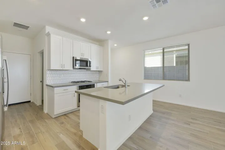 BEAUTIFUL PAINTED CABINETS, UPGRADED QUARTZ COUNTERS, DESIGNER BACKSPLASH, GAS COOKTOP, BUILT-IN OVEN AND REFRIGERATOR INCLUDED!!! PHOTOS ARE OF ANOTHER PLAN WITH SIMILAR OPTIONS