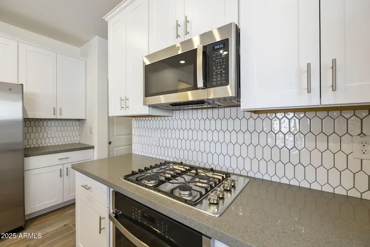BEAUTIFUL PAINTED CABINETS, UPGRADED QUARTZ COUNTERS, DESIGNER BACKSPLASH, GAS COOKTOP, BUILT-IN OVEN AND REFRIGERATOR INCLUDED!!! PHOTOS ARE OF ANOTHER PLAN WITH SIMILAR OPTIONS