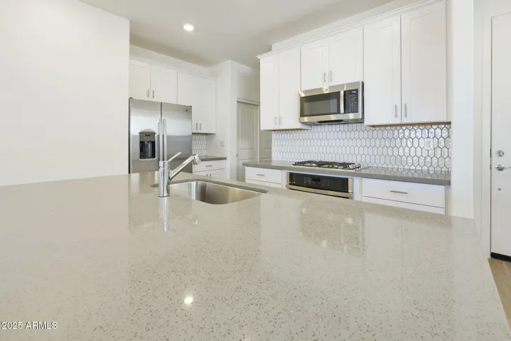 BEAUTIFUL PAINTED CABINETS, UPGRADED QUARTZ COUNTERS, DESIGNER BACKSPLASH, GAS COOKTOP, BUILT-IN OVEN AND REFRIGERATOR INCLUDED!!! PHOTOS ARE OF ANOTHER PLAN WITH SIMILAR OPTIONS