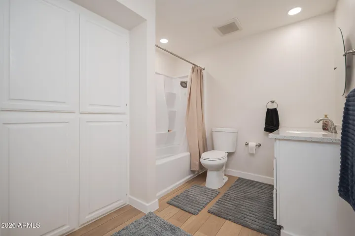 Updated hall bathroom features quartz counter top, wood-look tile floors + LOTS of storage!