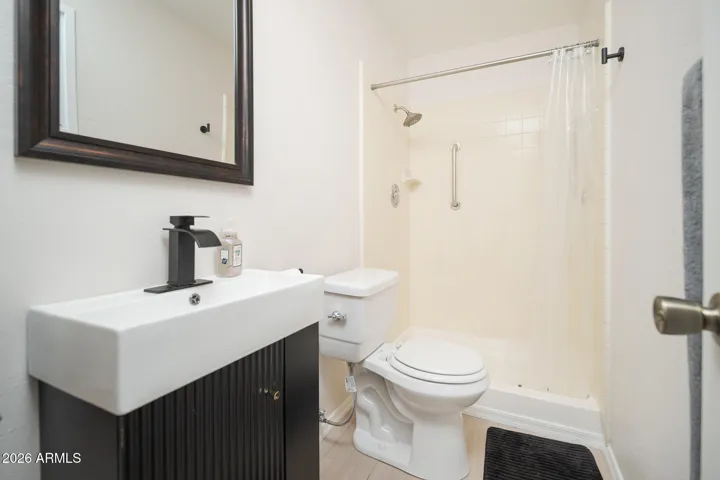 1st primary bathroom with updated vanity and mirror + tiled shower.