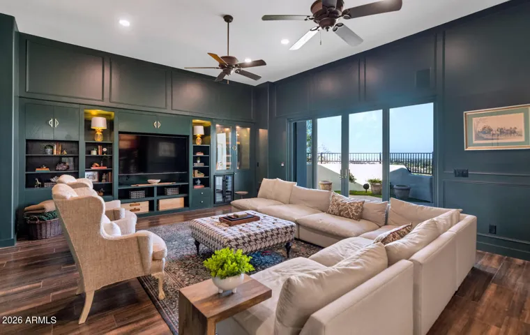 Custom built-in cabinetry, a spacious seating area, and a seamless indoor-outdoor feel with expansive glass doors. Ideal for entertaining, the space includes a stylish bar area complete with a sink and beverage fridge—perfect for hosting movie nights or relaxing with friends and family.