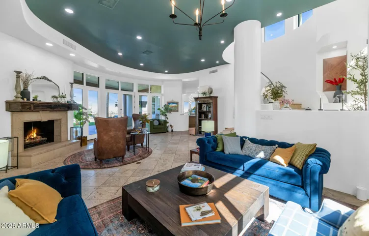 Step into a light-filled living space that blends comfort and architectural charm. This inviting great room features soaring ceilings with a stunning custom accent, a cozy fireplace, and expansive windows that flood the home with natural light.