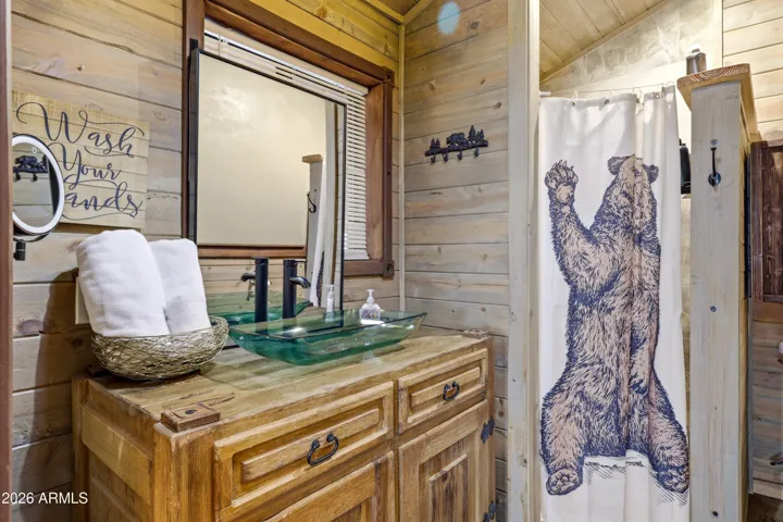 Cozy bathroom with wood finishes and cabin-style details.