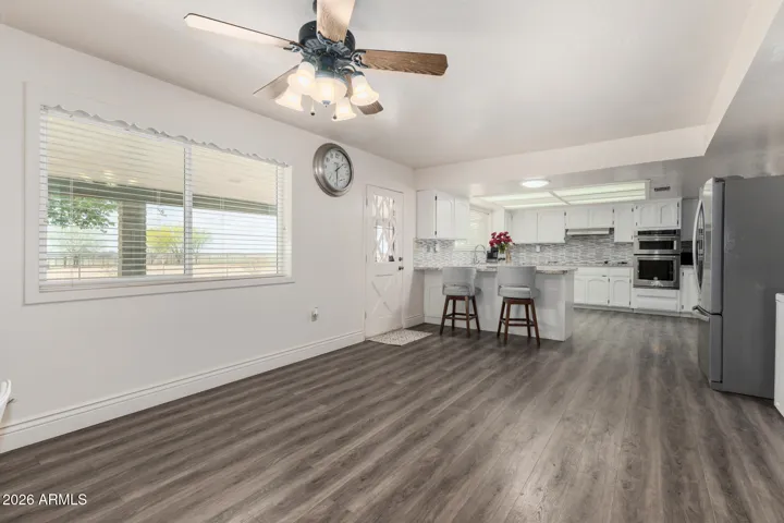 Spacious eating area of kitchen with picture windows overlooking backyard