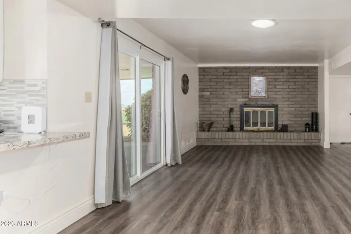 View from end of Dining room shows wood burning fireplace and Arcadia doors to private patio. Perfect for entertaining