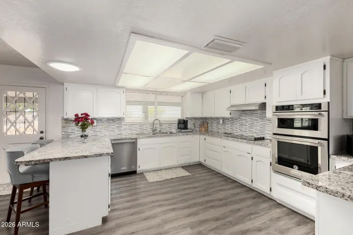 Large updated kitchen with granite countertops and stainless appliances.