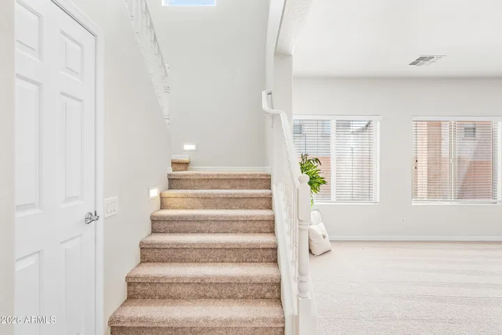 Linen closet downstairs with track lighting going up stairs