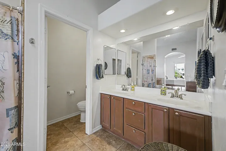 Primary bath also offers two sinks, cabinets with drawers.